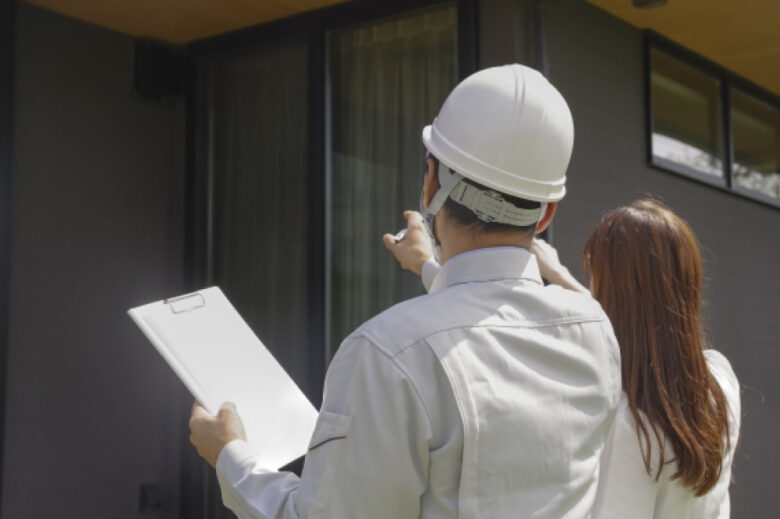 現地調査を行う業者と建物の持ち主の女性
